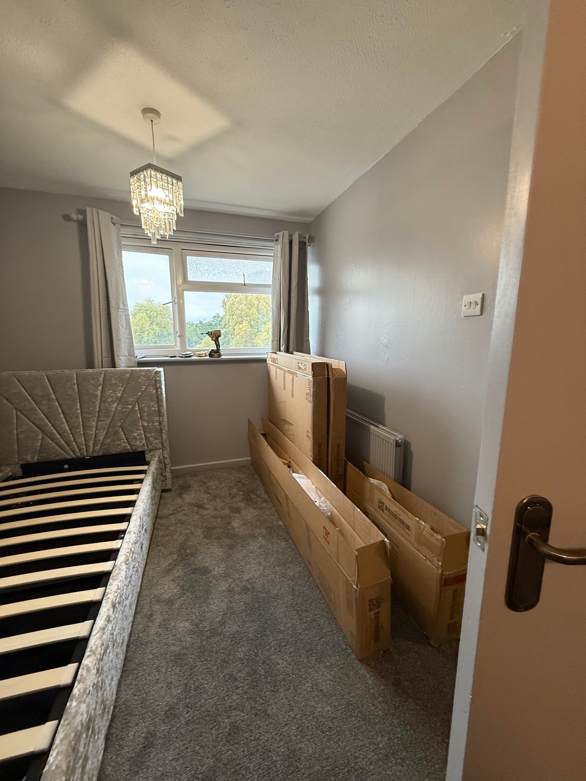 Completed bedroom with assembled bed frame, pendant lighting and wooden furniture
